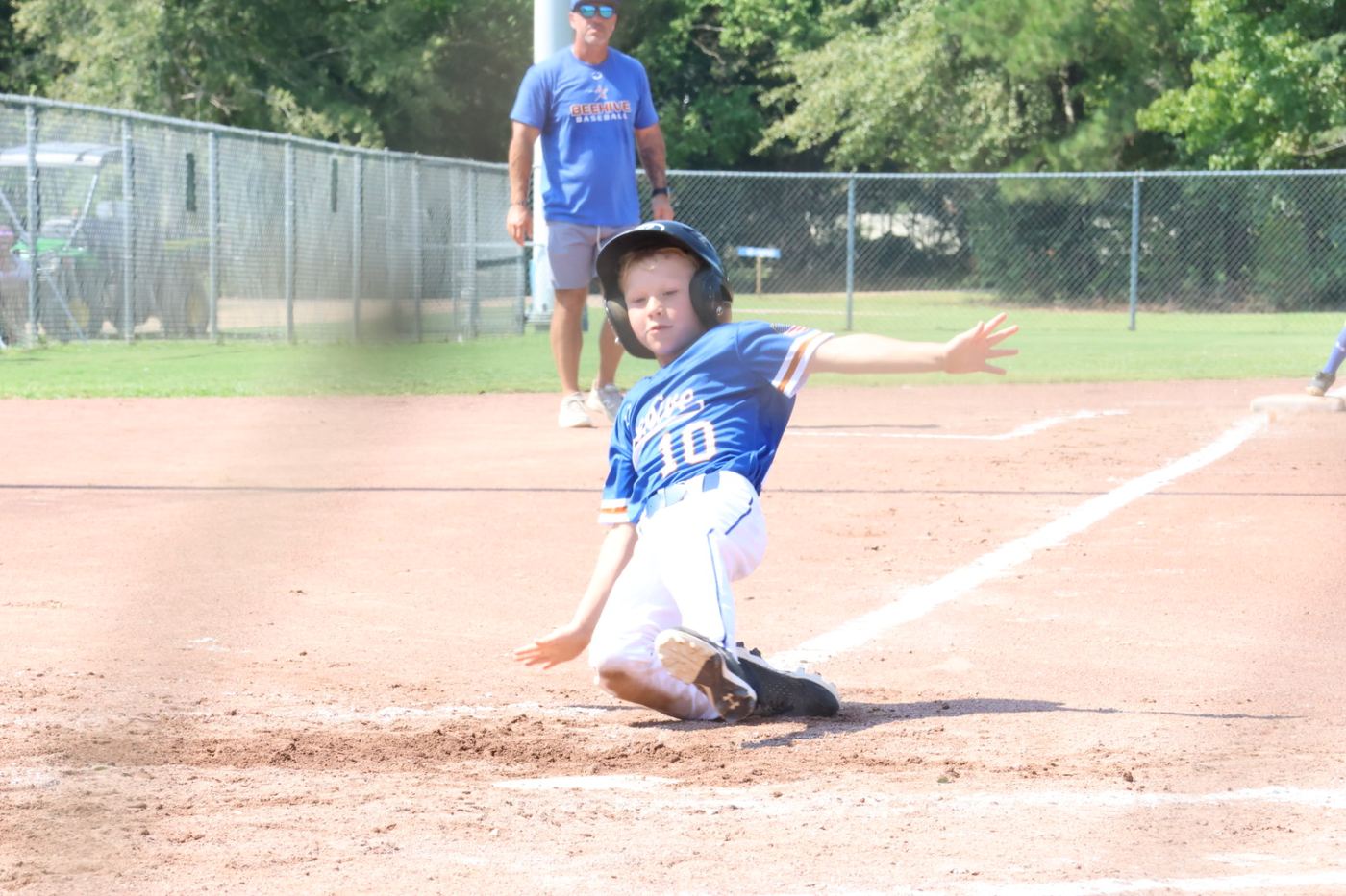 A 9U Beehive Stars runner sliding into home plate